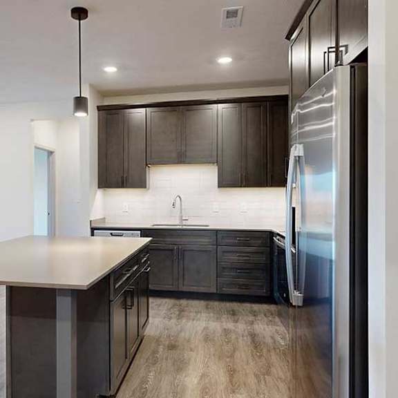 Thumbnail 3 of 28 a modern kitchen with dark wooden cabinets, quartz countertops, and a large central island
