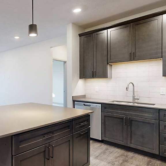 Thumbnail 8 of 28 a modern kitchen with dark wood cabinets and a large central island