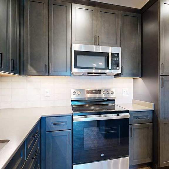Thumbnail 7 of 28 a modern kitchen with dark cabinets and stainless steel appliances