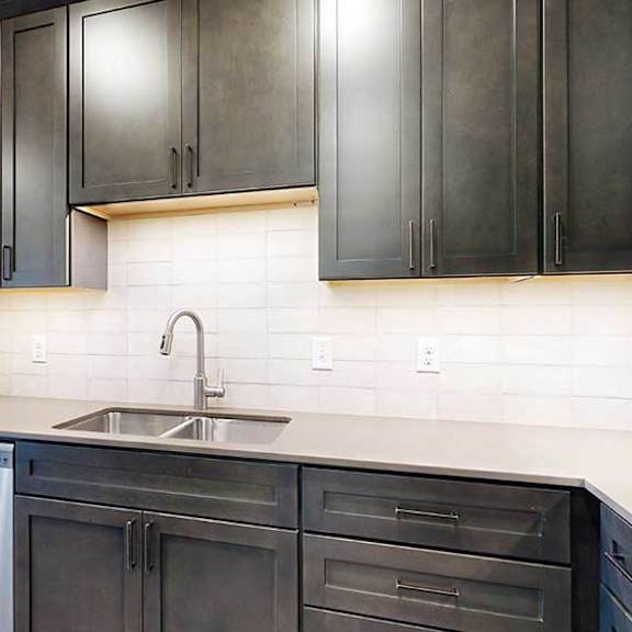 Thumbnail 6 of 28 a modern kitchen with dark cabinets and a white tile backsplash
