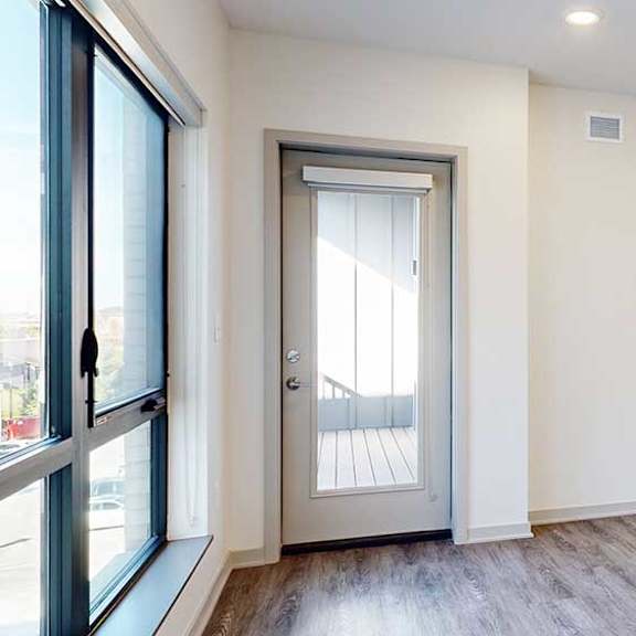 Thumbnail 10 of 28 a living room with hardwood flooring and a door to a balcony