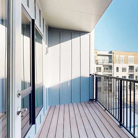 Thumbnail 13 of 24 A balcony with a metal railing, overlooking a courtyard.
