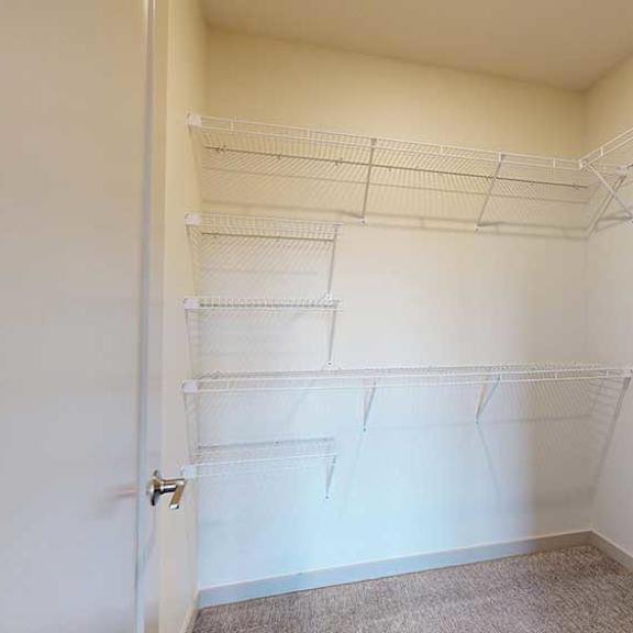 Thumbnail 21 of 24 An oversized walk-in closet with several built-in wire shelves.
