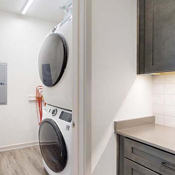 Thumbnail 24 of 24 A stacked full-sized washer and dryer in a laundry room.