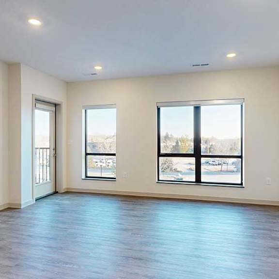 Thumbnail 11 of 24 A living room with hardwood-style flooring and floor-to-ceiling windows.