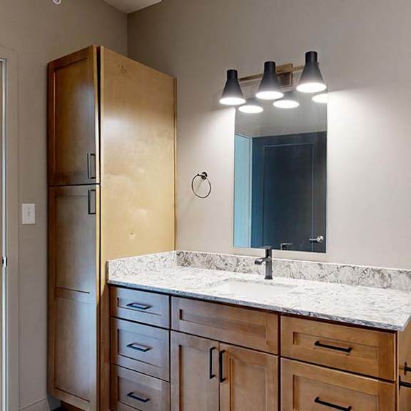 Thumbnail 68 of 84 Modern apartment bathroom with a single-sink vanity, wood cabinetry, and a large mirror.