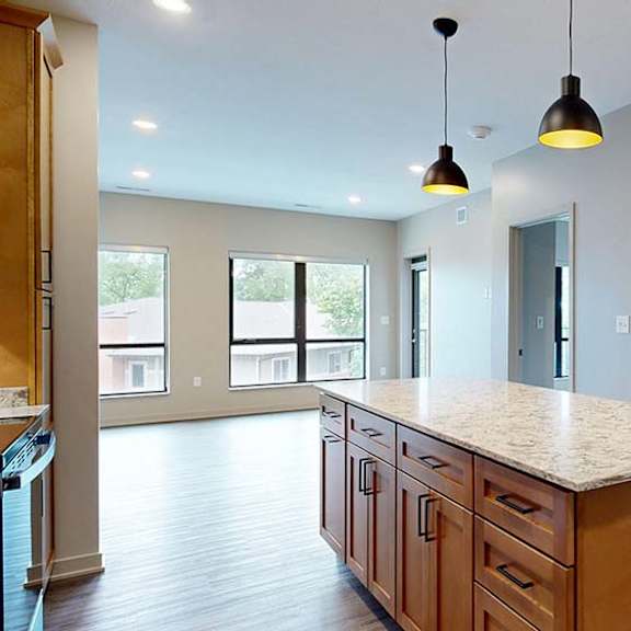 Thumbnail 57 of 84 Open apartment kitchen with a large island, pendant lighting, and an open layout to the living area.