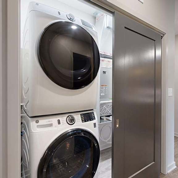 Thumbnail 47 of 84 In-home apartment laundry closet with a stacked washer and dryer, conveniently located just off the kitchen.
