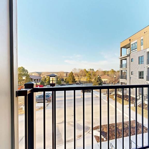Thumbnail 36 of 36 Private apartment balcony with views of the community and neighboring residential buildings.