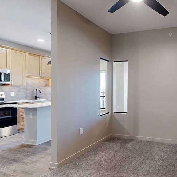 Thumbnail 32 of 36 Apartment dining area with carpeted flooring, a ceiling fan, and an open layout next to the kitchen.