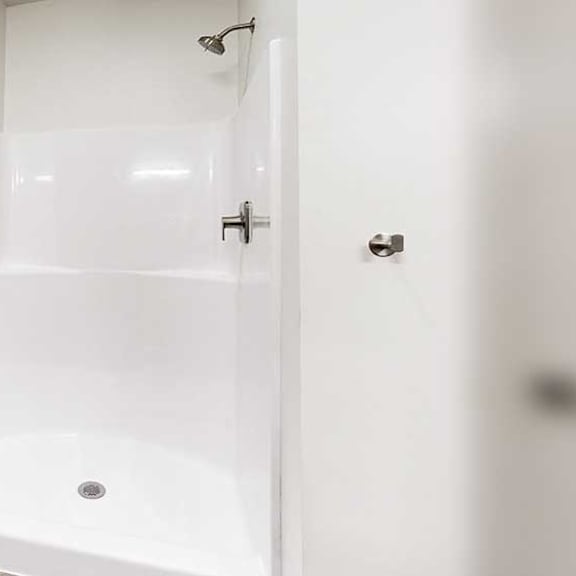 Thumbnail 20 of 30 a white walk-in shower with some built-in shelving