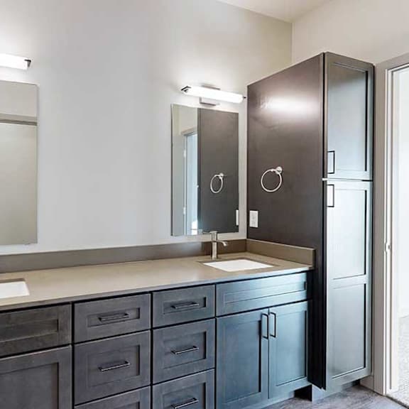 Thumbnail 19 of 30 a bathroom with a double vanity sink, two mirror, and a tall storage cabinet