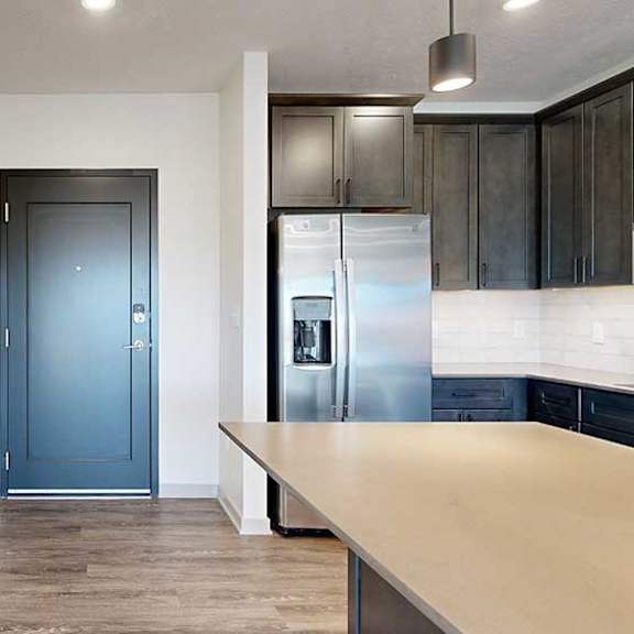 Thumbnail 2 of 30 a dark grey front door next to a modern kitchen