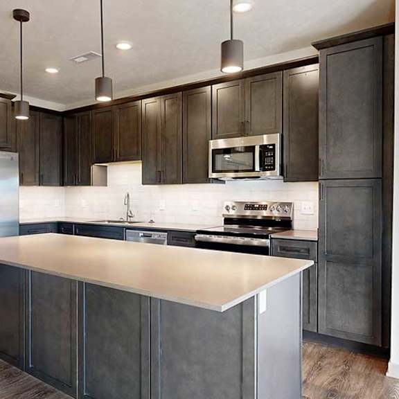 Thumbnail 5 of 30 a modern kitchen with dark wood cabinets and stainless steel appliances