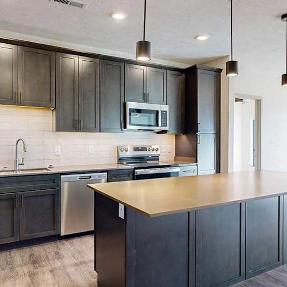 Thumbnail 6 of 30 a modern kitchen with dark wood cabinets and stainless steel appliances