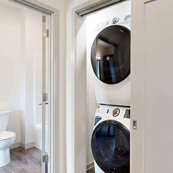Thumbnail 23 of 30 a stackable full-sized washer and dryer in a laundry closet in the hallway