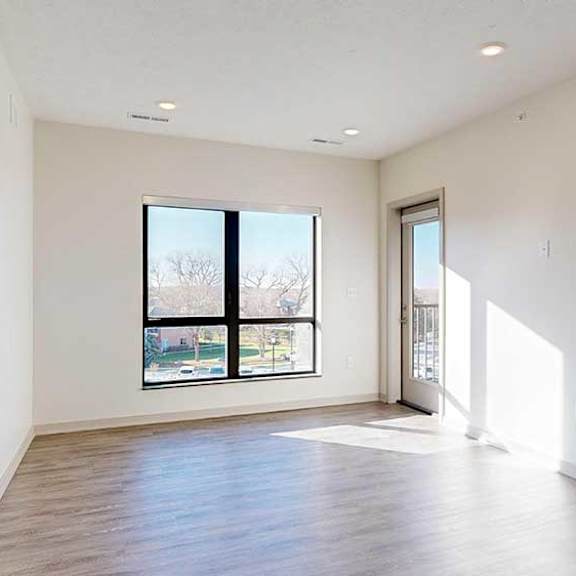 Thumbnail 10 of 30 a living room with a window and hardwood flooring