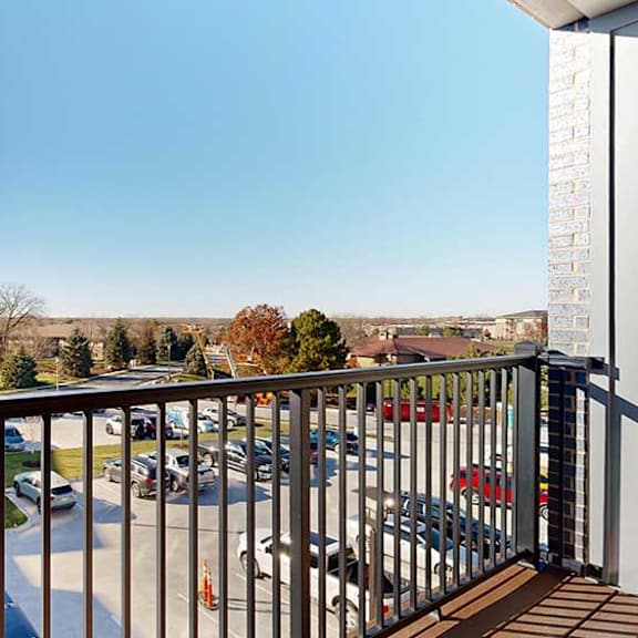 Thumbnail 13 of 30 a balcony with a metal railing and surrounding parking area