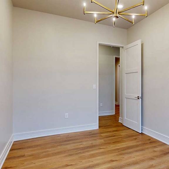 Thumbnail 29 of 46 A separate dining room with a metal chandelier and hardwood flooring.