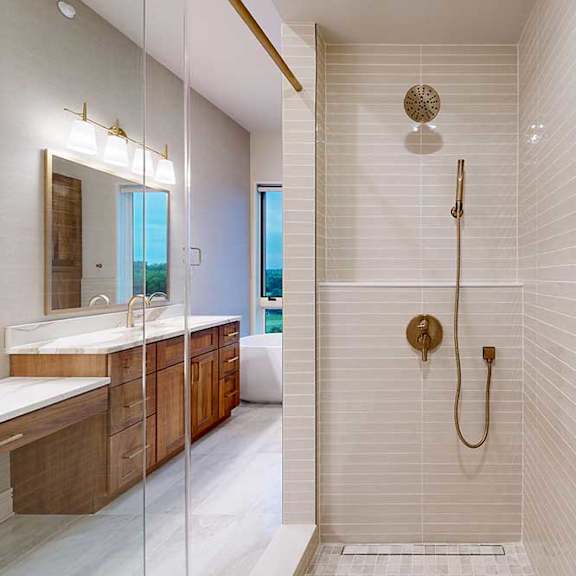 Thumbnail 43 of 46 A tiled walk-in shower with a sliding glass door, and a shower head with detached sprayer.