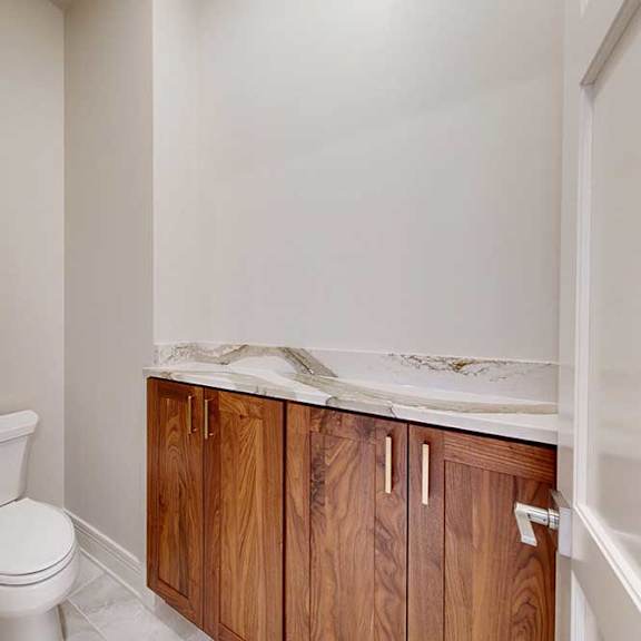 Thumbnail 45 of 46 A bathroom with a private lavatory with built-in cabinet and quartz countertop.