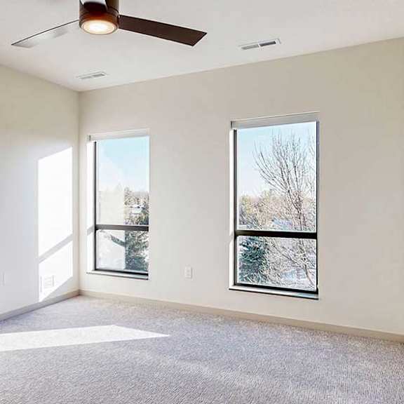 Thumbnail 18 of 33 a bedroom with carpeted flooring, two windows, and a ceiling fan