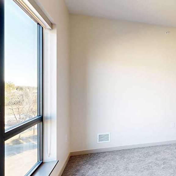 Thumbnail 25 of 33 a bedroom with a carpeted floor, a large window, and a spacious walk-in closet
