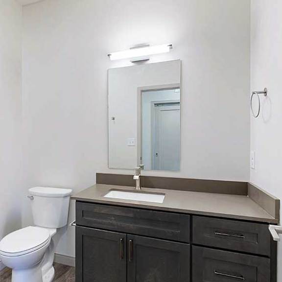 Thumbnail 31 of 33 a bathroom with a quartz vanity sink, a mirror with overhead lighting, and a combination shower and tub