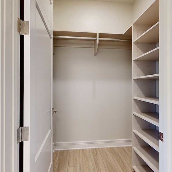 Thumbnail 4 of 31 A white closet with built-in shelves and a door.