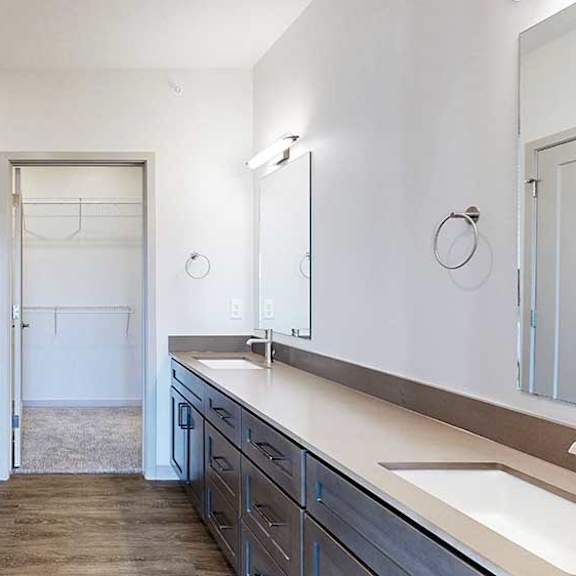 Thumbnail 20 of 30 a bathroom with a double sink vanity and an attached walk-in closet
