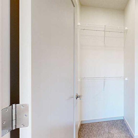 Thumbnail 25 of 30 an L-shaped walk-in closet with built-in shelving