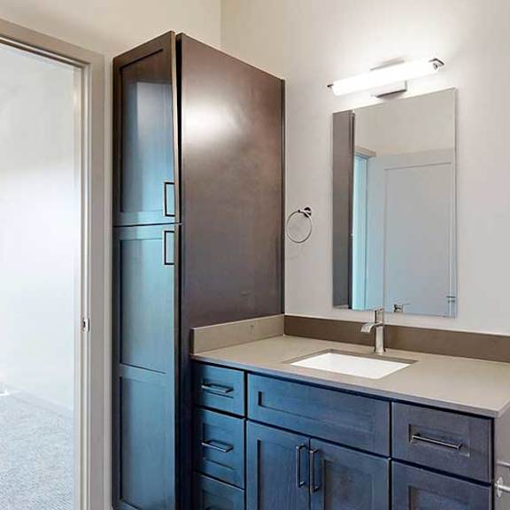 Thumbnail 26 of 30 a bathroom with dark wooden cabinet and a quartz vanity sink