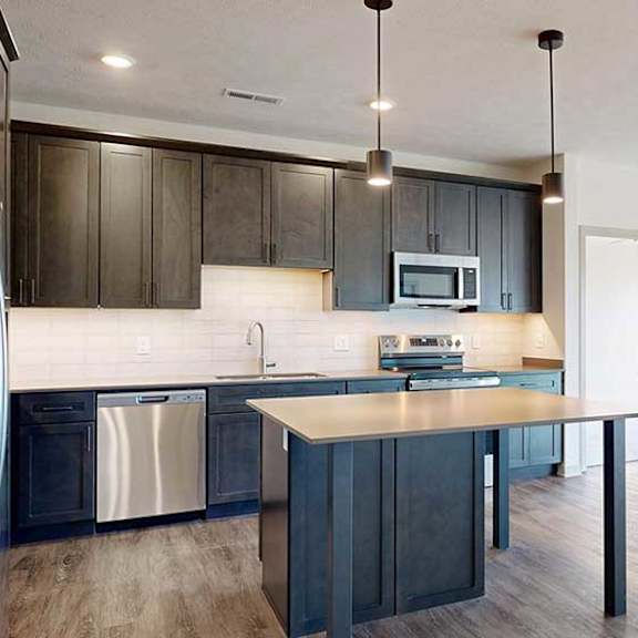 Thumbnail 7 of 30 a modern kitchen with dark wood cabinets and stainless steel appliances