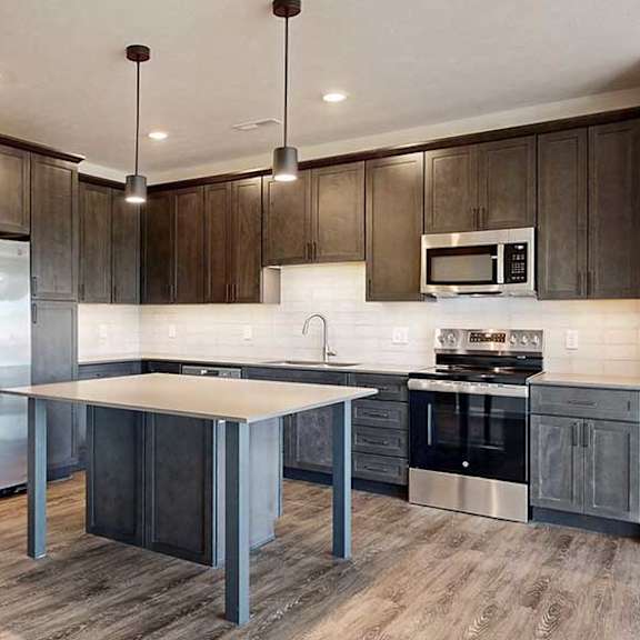 Thumbnail 4 of 30 a modern kitchen with dark wood cabinets and stainless steel appliances
