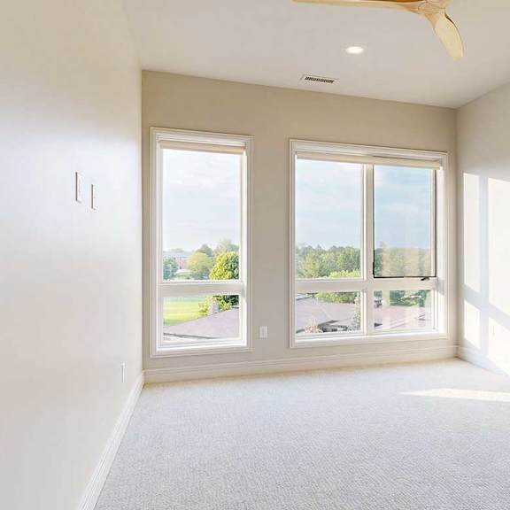 Thumbnail 23 of 41 A carpeted with floor-to-ceiling windows and a ceiling fan.