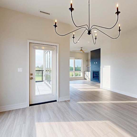 Thumbnail 12 of 41 A large dining room with a wire chandelier and hardwood-style flooring, open to a spacious living room.