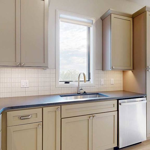 Thumbnail 10 of 41 A gourmet kitchen with taupe cabinetry, quartz countertops, a tile backsplash, and a window over the kitchen sink.