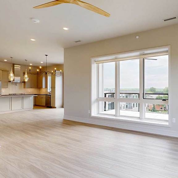 Thumbnail 17 of 41 A modern living room with hardwood-style flooring, two floor-to-ceiling windows, and a large ceiling fan.