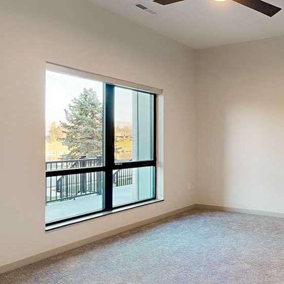 Thumbnail 16 of 26 a bedroom with a large window and a ceiling fan