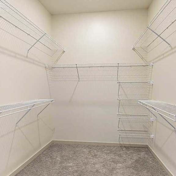 Thumbnail 19 of 26 a large walk-though closet with built-in wired shelving and hanging space