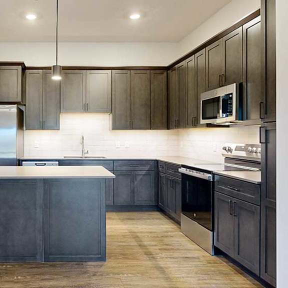 Thumbnail 6 of 26 a modern kitchen with dark wood cabinets and stainless steel appliances