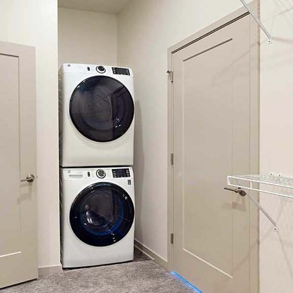 Thumbnail 21 of 26 a stackable white washer and dryer in a laundry closet