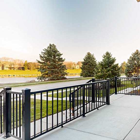 Thumbnail 12 of 26 a walk-out patio with a black metal fence surrounding it