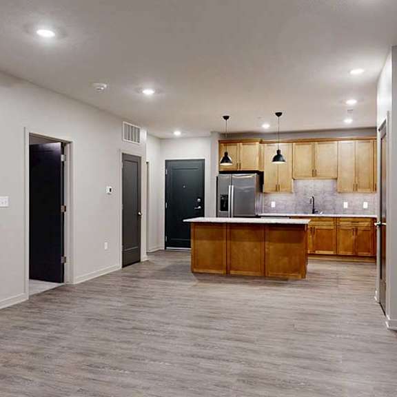 Thumbnail 25 of 26 a living room with a kitchen in the background