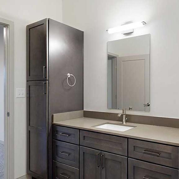 Thumbnail 22 of 25 a bathroom with a sink, mirror, and tall storage cabinet