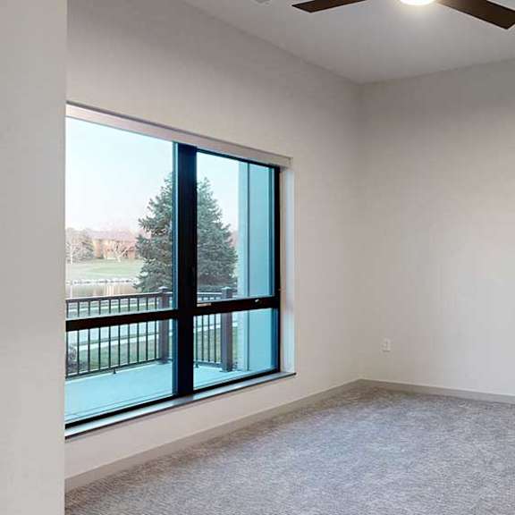 Thumbnail 16 of 25 a bedroom with a large window and a ceiling fan