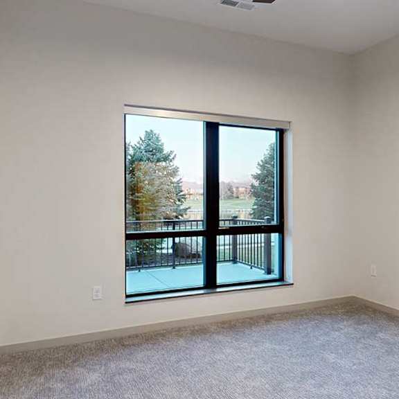 Thumbnail 17 of 25 a bedroom with a large window overlooking a patio and trees