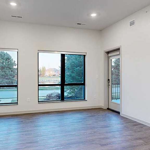 Thumbnail 10 of 25 a spacious living room with a door and two large windows