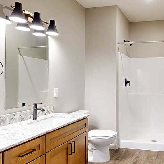 Thumbnail 32 of 33 A bathroom with a walk-in shower with black fixtures.