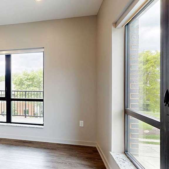 Thumbnail 14 of 33 A living room with hardwood-style flooring and large floor-to-ceiling windows.